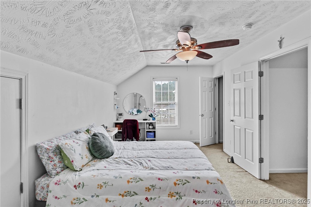 6657 Hillbrook Road Hope Mills, NC 28348 - Photo 31 of 50 a bedroom with a large bed and a chandelier