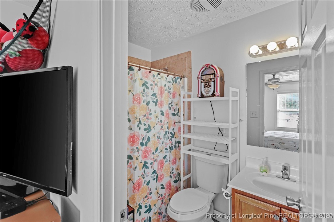 6657 Hillbrook Road Hope Mills, NC 28348 - Photo 32 of 50 a bathroom with a sink toilet vanity and shower