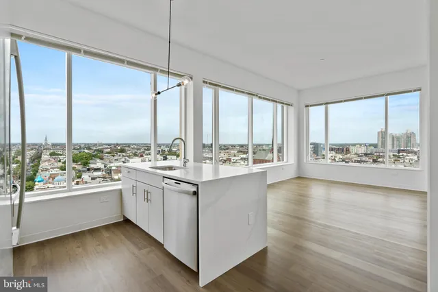 a kitchen with a large window and wooden floor