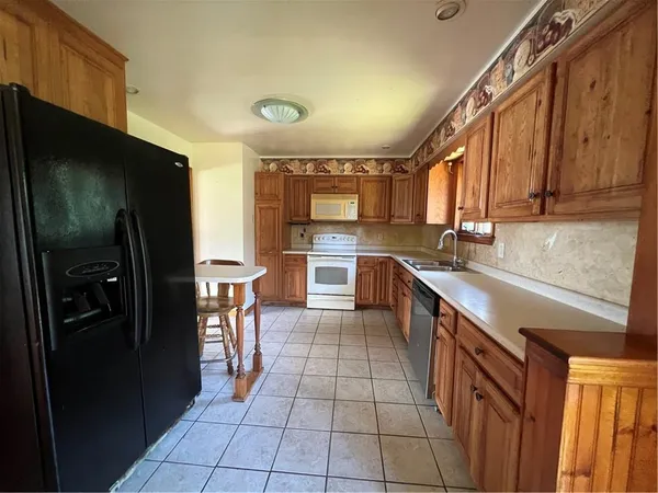 a kitchen with stainless steel appliances granite countertop a refrigerator and a sink