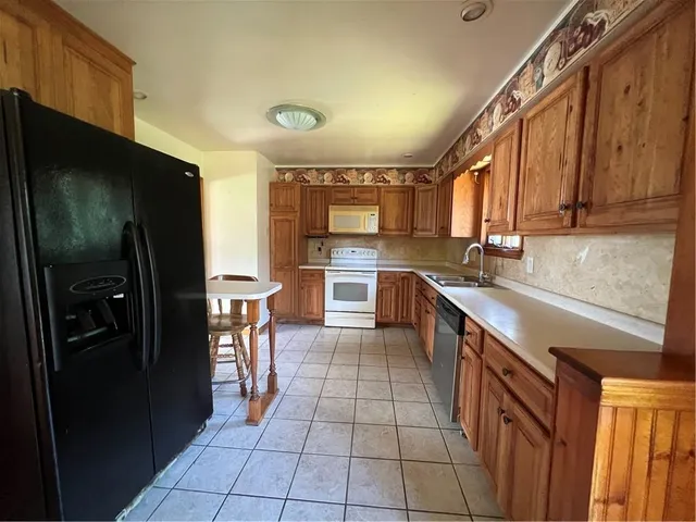 a kitchen with stainless steel appliances granite countertop a refrigerator and a sink