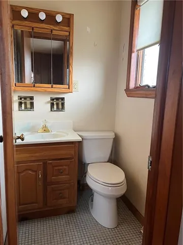a bathroom with a toilet sink and mirror