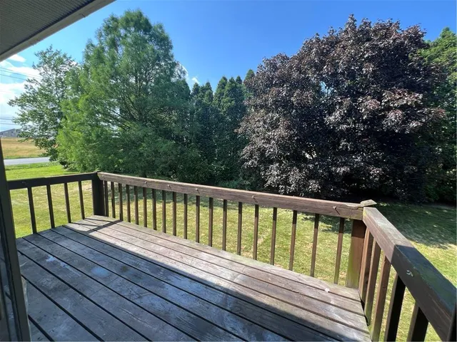 a view of balcony with wooden floor and fence