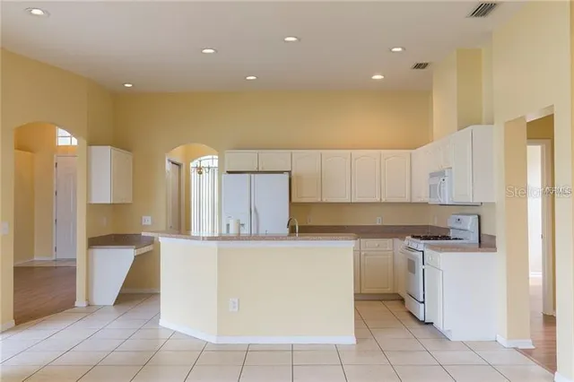 a kitchen with a sink a counter top space stainless steel appliances and cabinets
