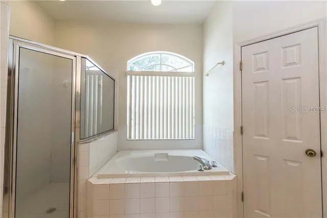 a bathroom with a bathtub a shower and a sink