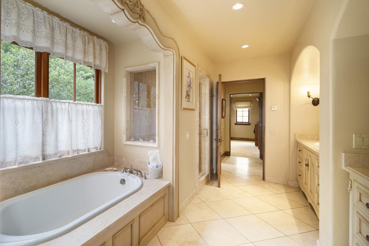 1606 Sonado Road Pebble Beach, CA 93953 - Photo 27 of 47 a bathroom with a tub a sink and a large mirror