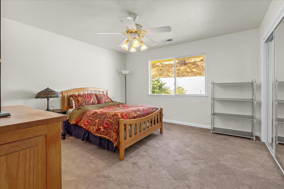 817 Lewis Road Watsonville, CA 95076 - Photo 18 of 27 a bedroom with a bed and a chandelier