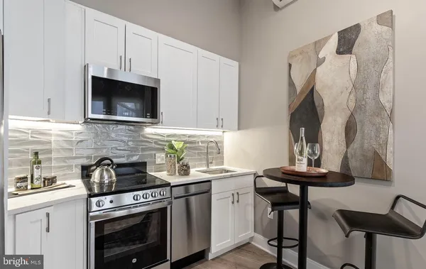 a kitchen with stainless steel appliances a stove a sink and a microwave