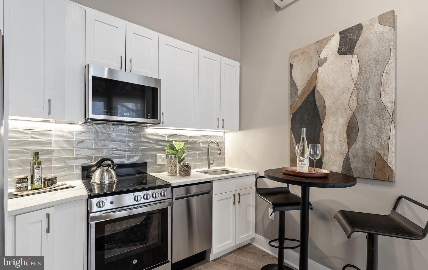 a kitchen with stainless steel appliances a stove a sink and a microwave