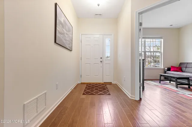 a view of a bedroom with wooden floor and furniture
