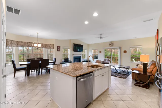 a dining hall with stainless steel appliances granite countertop a table and chairs