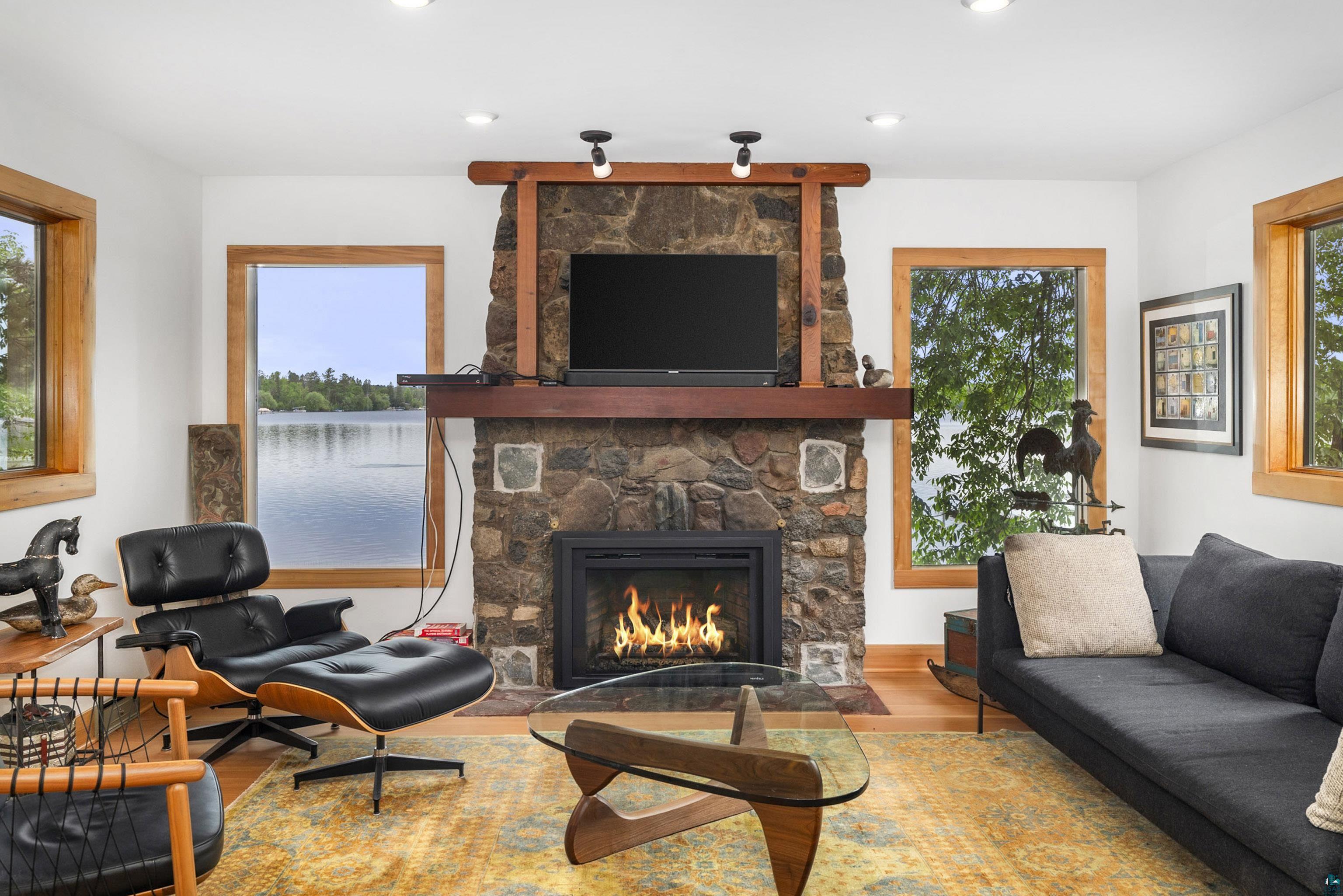5791 South Pike Lake Road Duluth, MN 55811 - Photo 16 of 50 Living room featuring a stone fireplace and hardwood / wood-style flooring