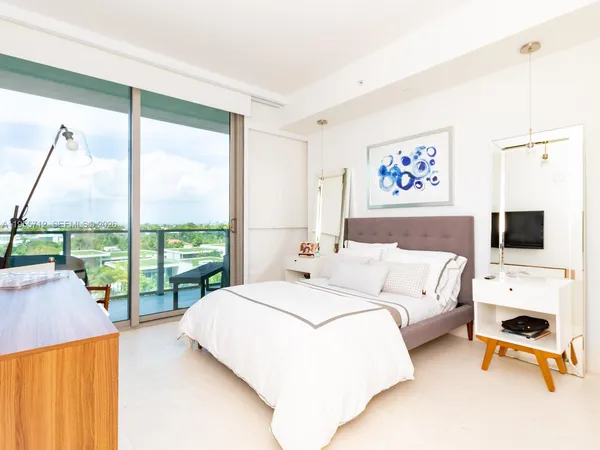 a bedroom with a large bed and a chandelier