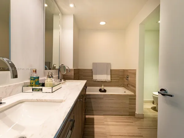 a bathroom with a tub a toilet and a shower