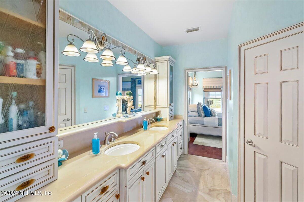 4295 Heath Road Jacksonville, FL 32277 - Photo 43 of 64 a spacious en suite bathroom with a double vanity sink and a large mirror