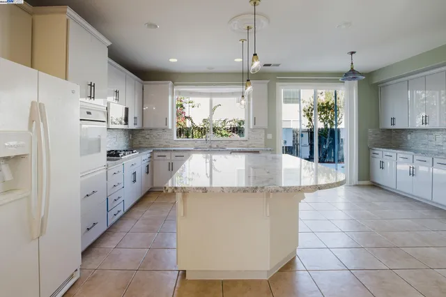 a kitchen with granite countertop a sink stainless steel appliances and cabinets