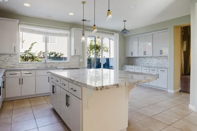 a kitchen with granite countertop a sink window and cabinets