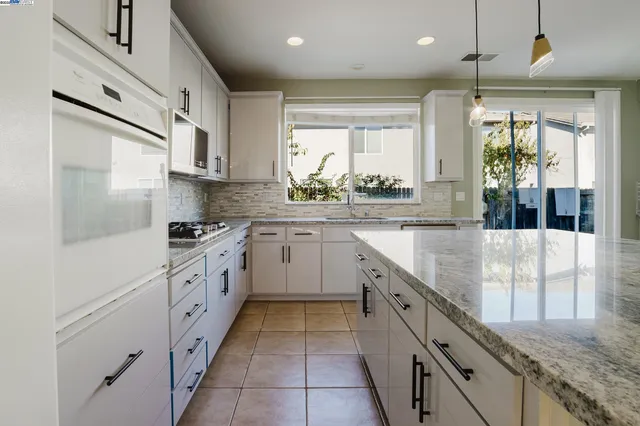 a kitchen with stainless steel appliances granite countertop a stove a sink and a refrigerator