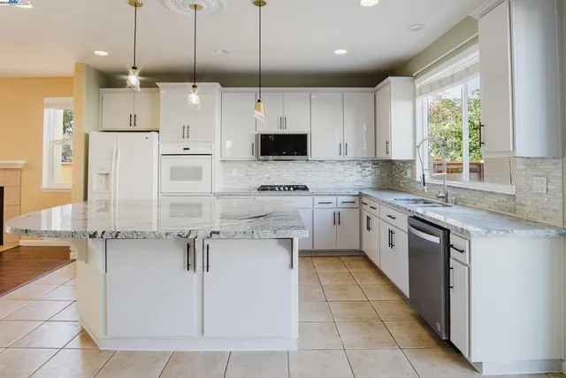 a kitchen with granite countertop a sink stainless steel appliances and cabinets