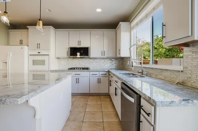 a view of an empty room with wooden floor fireplace and a window