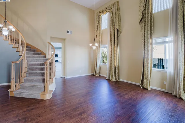 a view of a hallway with wooden floor and stairs