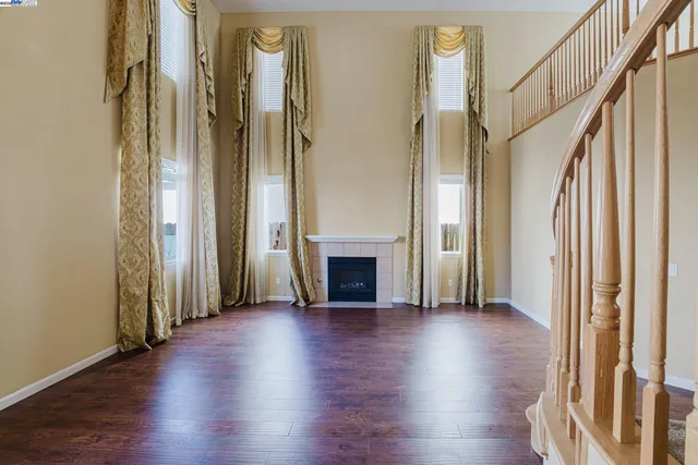 a view of a livingroom with wooden floor and a fireplace