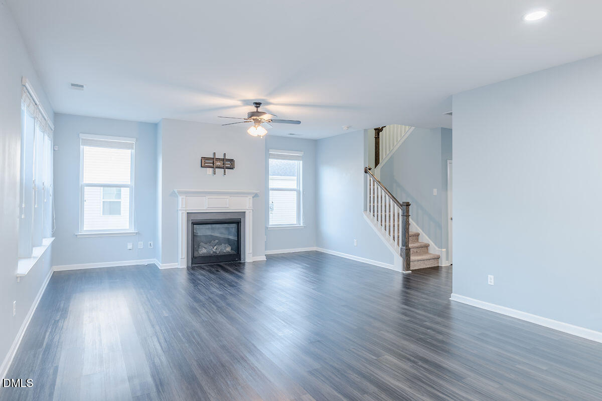 87 East Ravano Drive Clayton, NC 27527 - Photo 11 of 37 a view of an empty room with wooden floor fireplace and a window