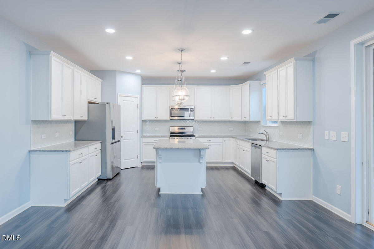87 East Ravano Drive Clayton, NC 27527 - Photo 13 of 37 a kitchen with a white wooden cabinets stove top oven and refrigerator