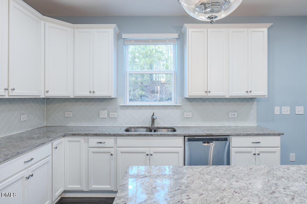 87 East Ravano Drive Clayton, NC 27527 - Photo 16 of 37 a kitchen with granite countertop white cabinets white appliances and a granite counter tops