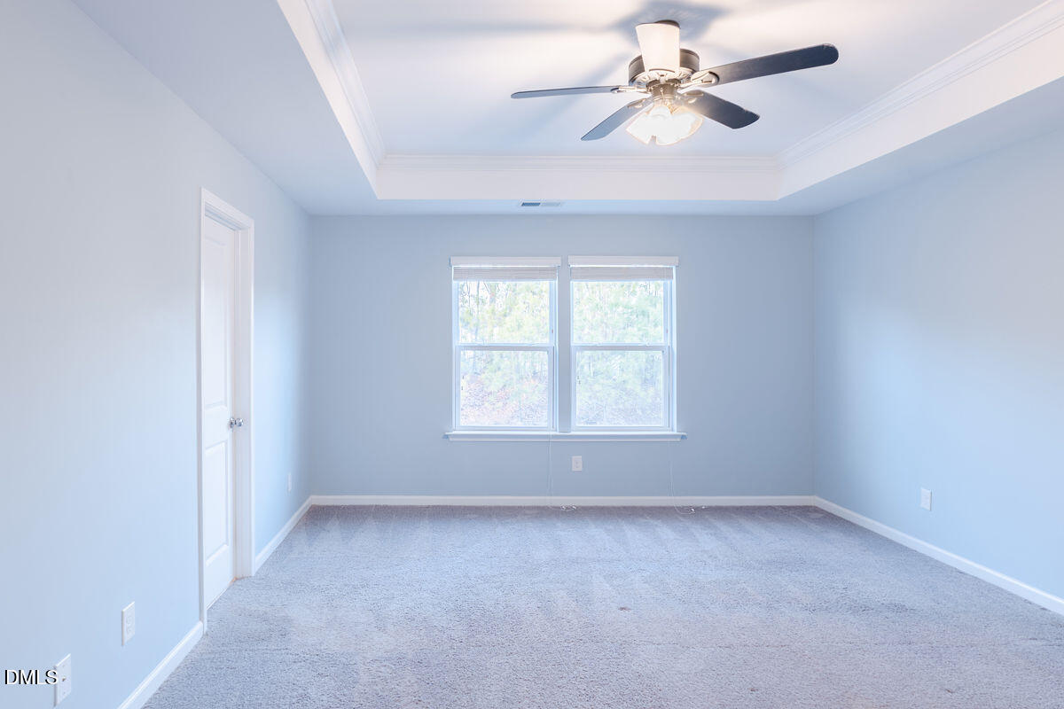 87 East Ravano Drive Clayton, NC 27527 - Photo 22 of 37 an empty room with a chandelier fan and windows