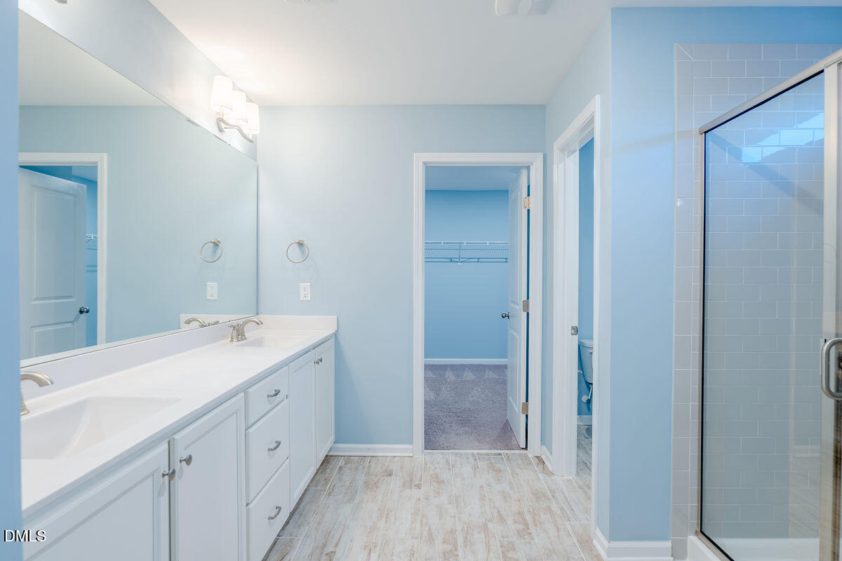 87 East Ravano Drive Clayton, NC 27527 - Photo 24 of 37 a spacious bathroom with a double vanity sink a mirror and a shower