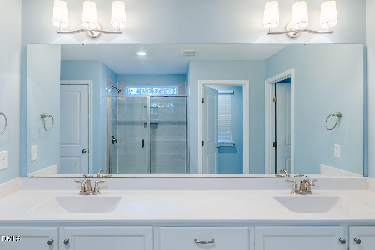 87 East Ravano Drive Clayton, NC 27527 - Photo 25 of 37 a bathroom with a sink a mirror and a shower