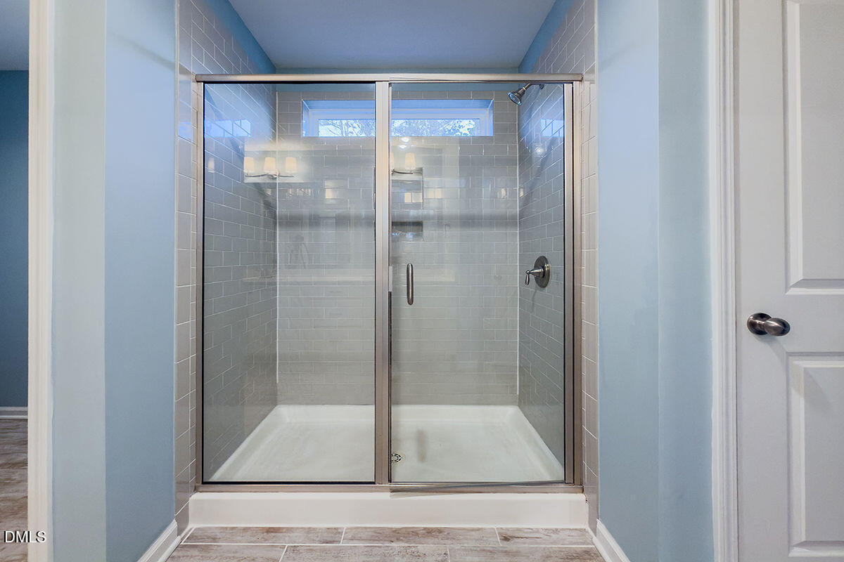 87 East Ravano Drive Clayton, NC 27527 - Photo 26 of 37 a bathroom with a glass shower door