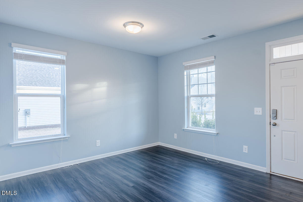 87 East Ravano Drive Clayton, NC 27527 - Photo 7 of 37 an empty room with wooden floor and windows