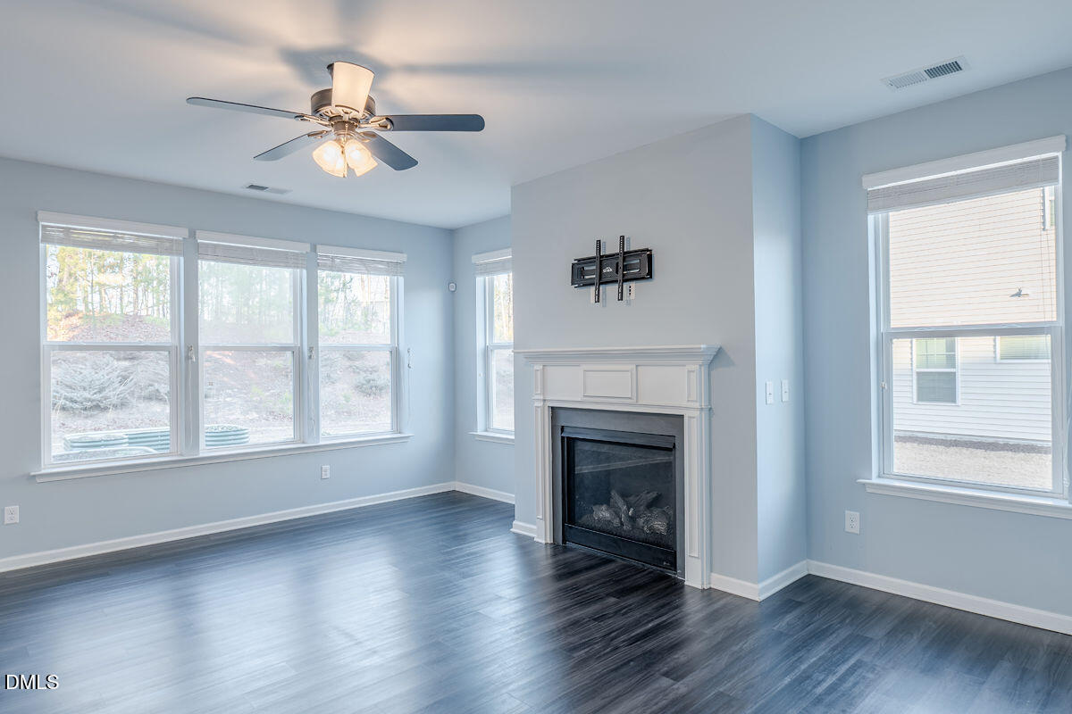 87 East Ravano Drive Clayton, NC 27527 - Photo 10 of 37 a view of an empty room with wooden floor and a window