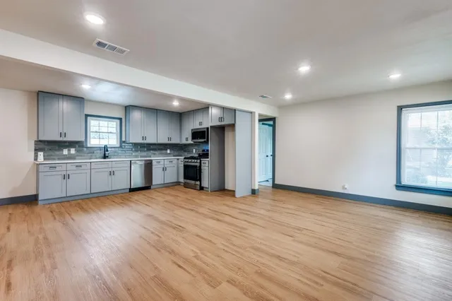 a large kitchen with stainless steel appliances granite countertop a stove a sink and a refrigerator