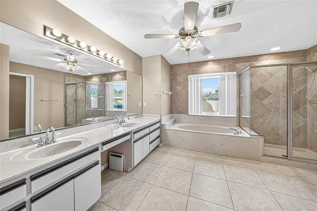 a spacious bathroom with a granite countertop sink a large mirror and a bathtub
