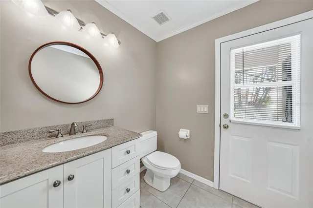 a bathroom with a granite countertop toilet a sink and a mirror