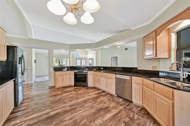 a large kitchen with cabinets wooden floor and stainless steel appliances