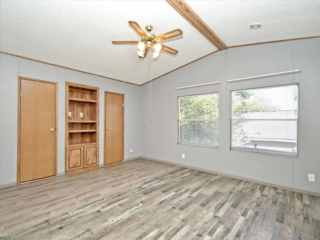 223 Golf Course Drive Spicewood, TX 78669 - Photo 13 of 38 a view of an empty room with wooden floor and a window