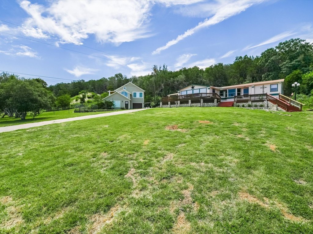 223 Golf Course Drive Spicewood, TX 78669 - Photo 3 of 38 a front view of a house with a garden