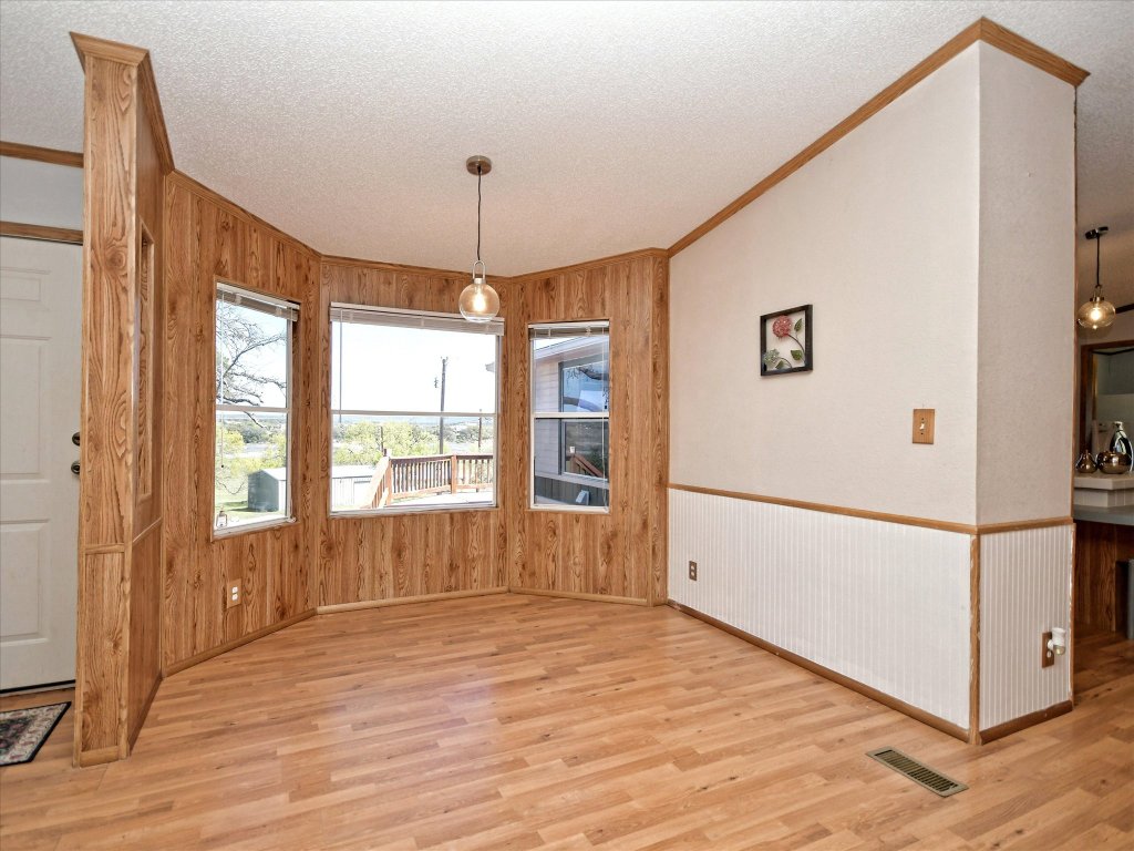 223 Golf Course Drive Spicewood, TX 78669 - Photo 4 of 38 a view of an empty room with wooden floor and a window