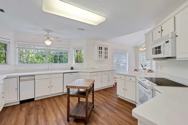 a kitchen with white cabinets and sink