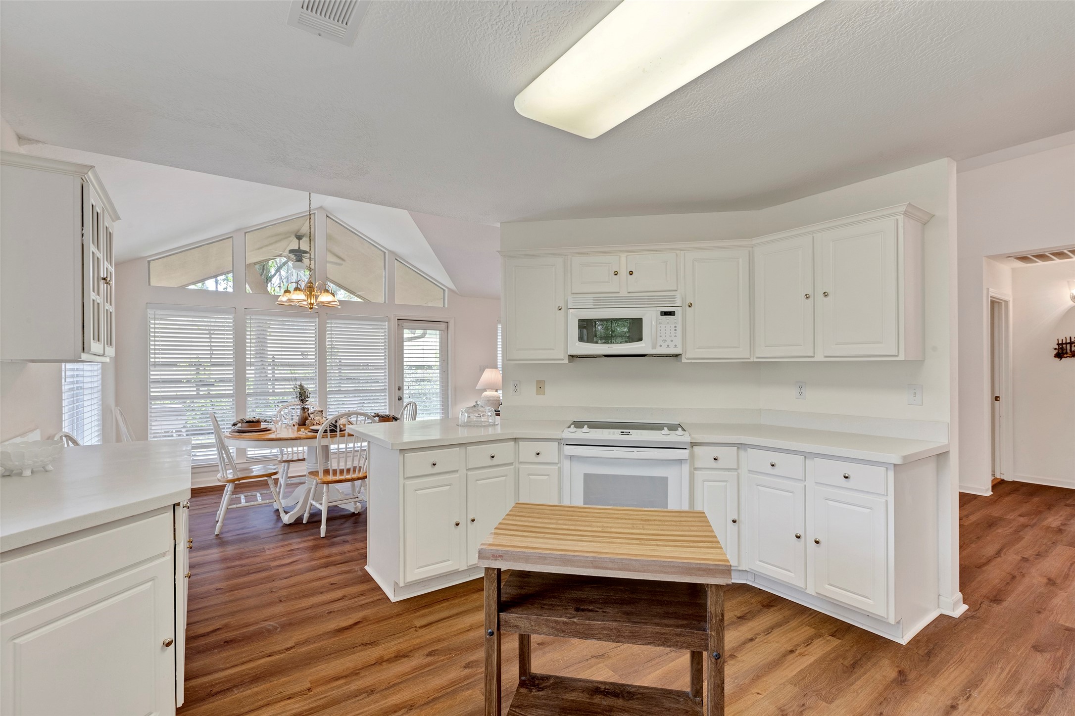 281 Harbor Run Drive Coldspring, TX 77331 - Photo 14 of 31 a kitchen with stainless steel appliances a stove a sink dishwasher and white cabinets with wooden floor