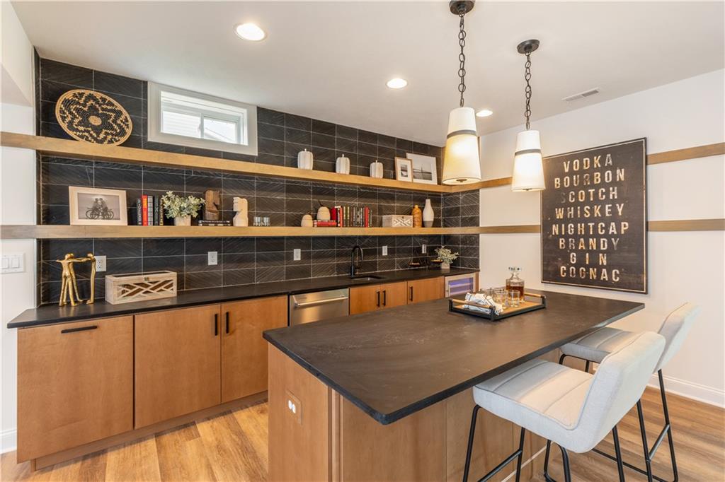 5136 Cline Hollow Road Export, PA 15632 - Photo 25 of 25 a room with stainless steel appliances kitchen island granite countertop a table chairs in it and wooden floor