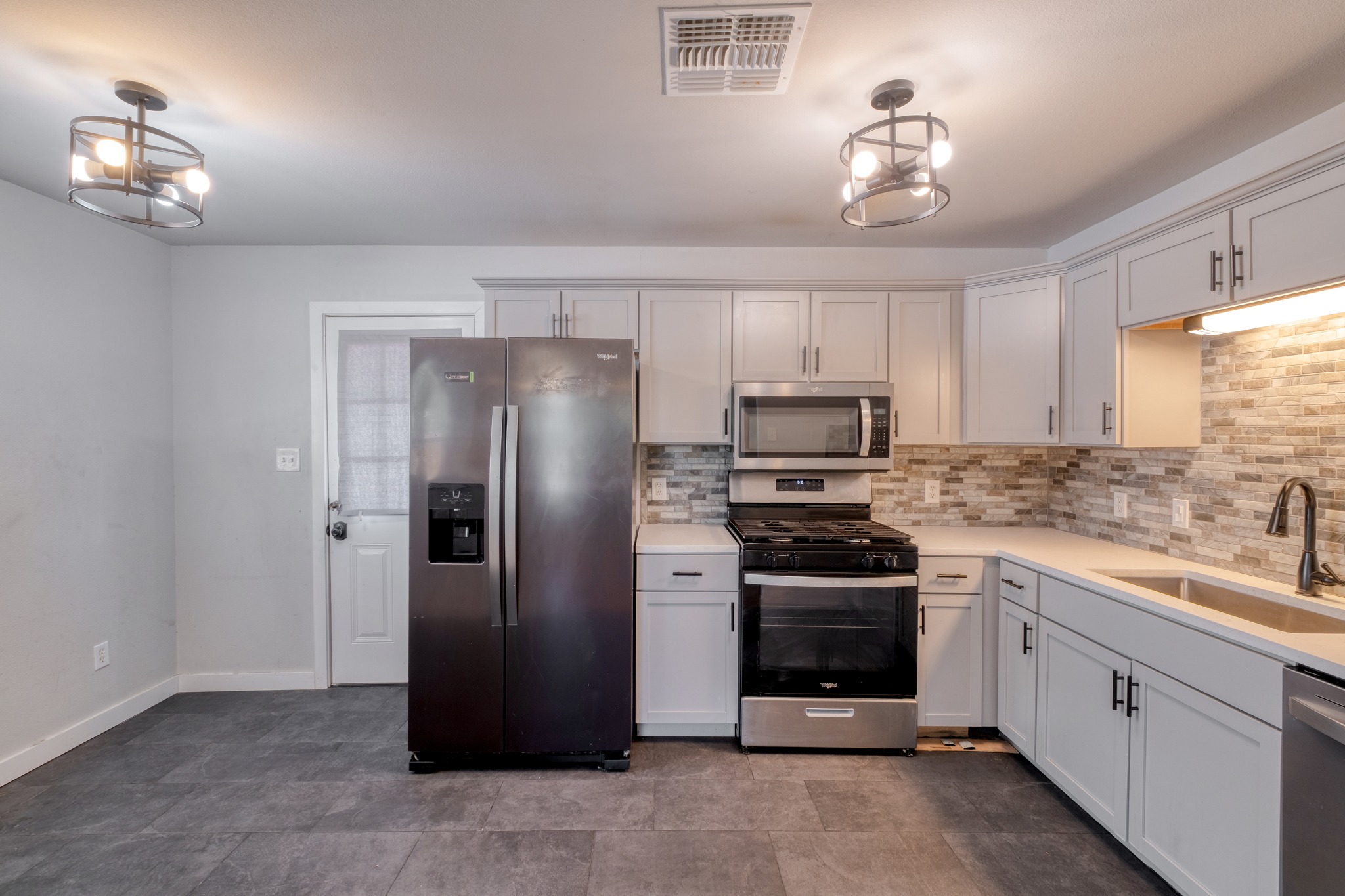 1719 Adina Street Austin, TX 78721 - Photo 8 of 17 The kitchen has hard tile flooring.