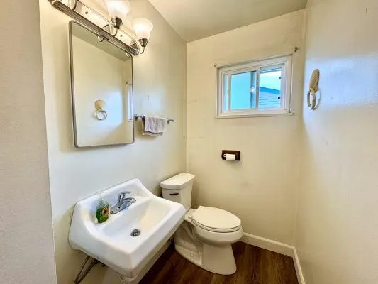 a bathroom with a toilet sink and mirror