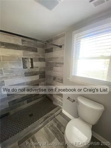 a bathroom with a toilet a sink and a window