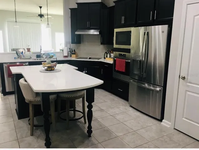 a kitchen with stainless steel appliances a sink stove and refrigerator