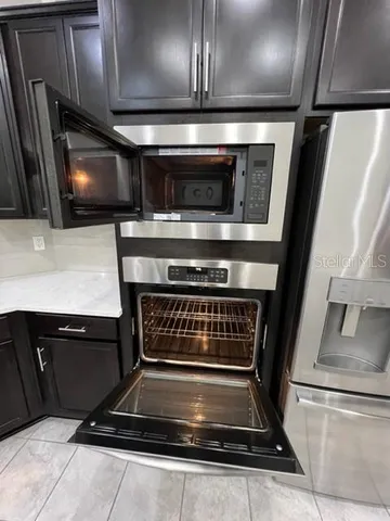 a kitchen with kitchen island a counter top space appliances and cabinets